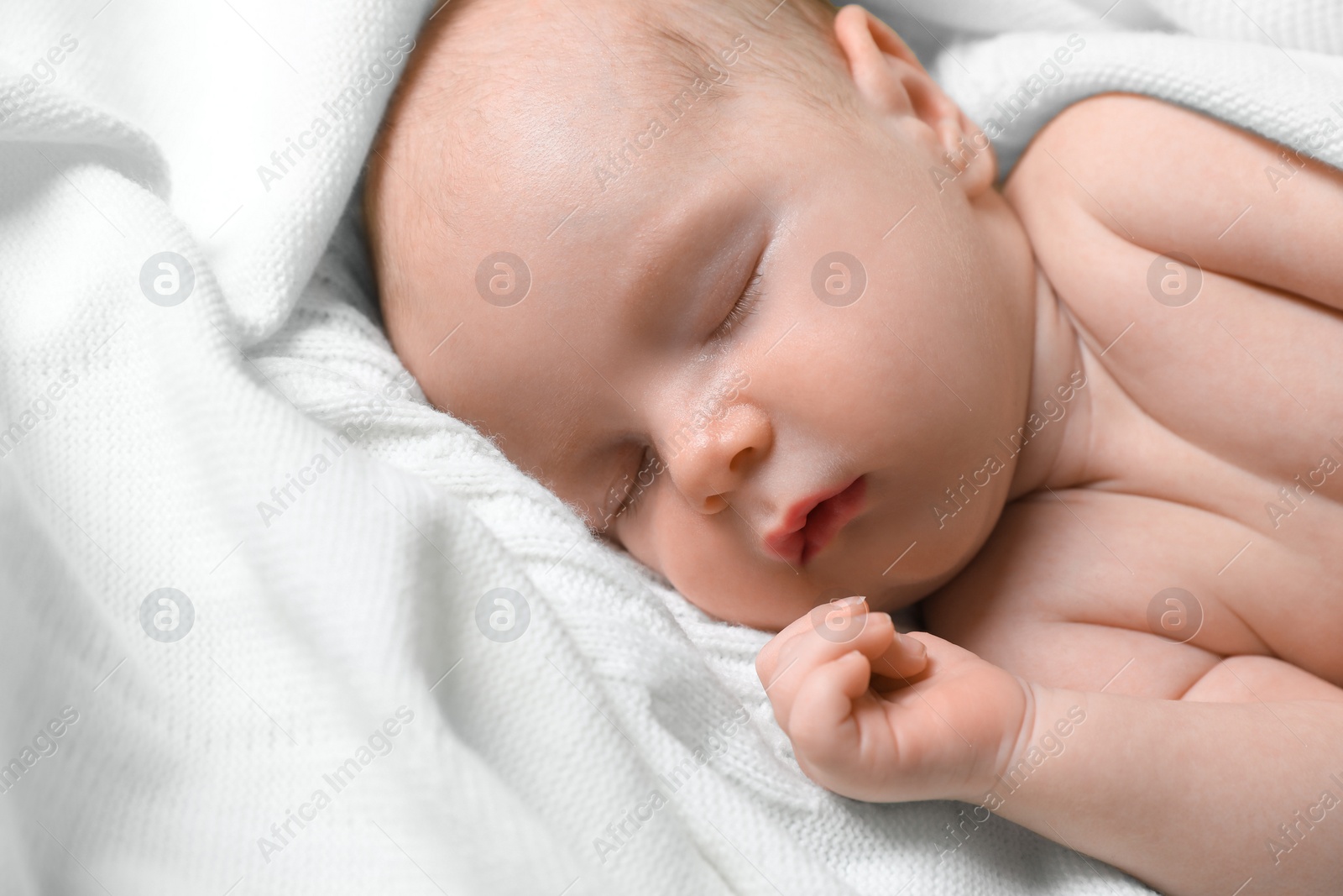 Photo of Cute newborn baby sleeping on white blanket, closeup