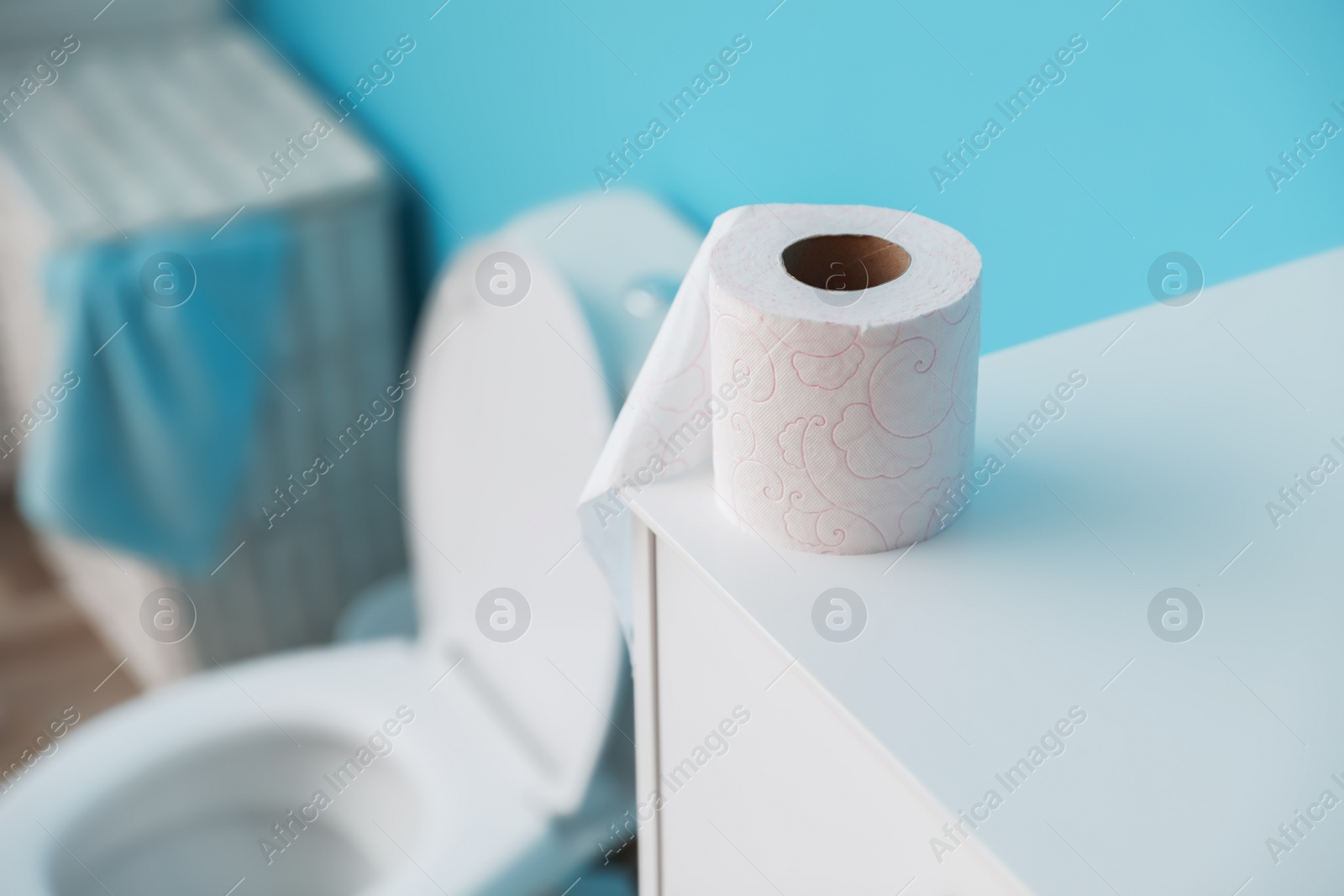 Photo of Toilet paper roll on cabinet in bathroom. Space for text