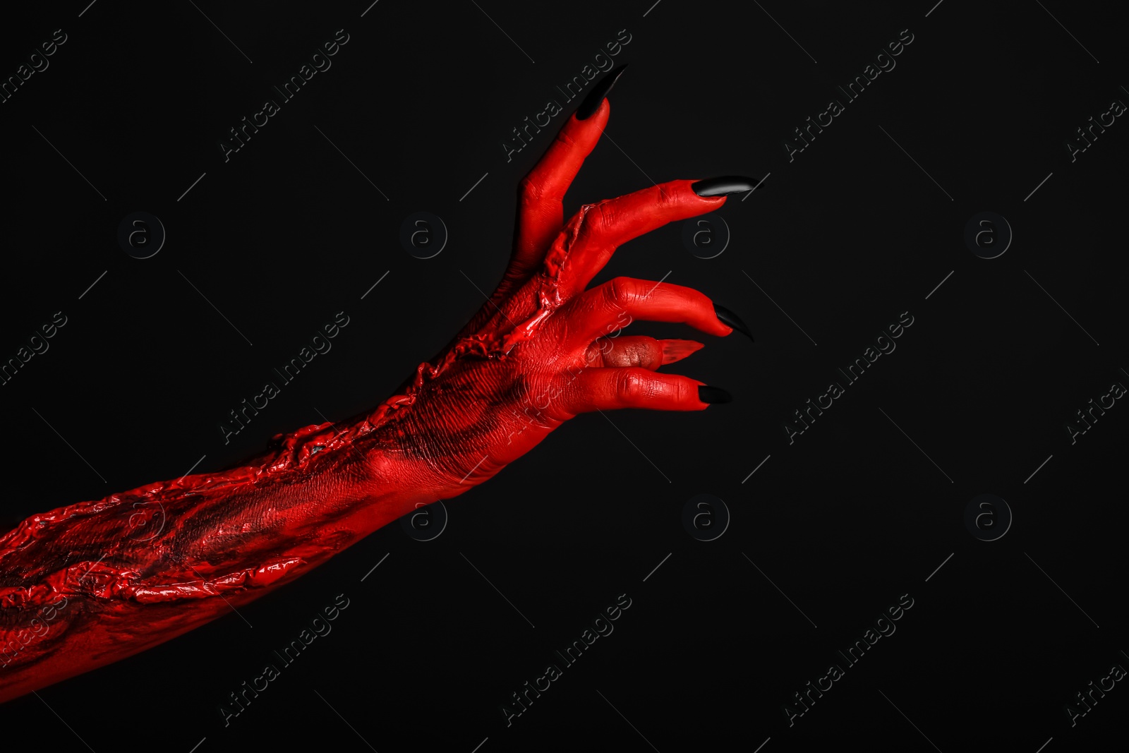 Photo of Scary monster on black background, closeup of hand. Halloween character