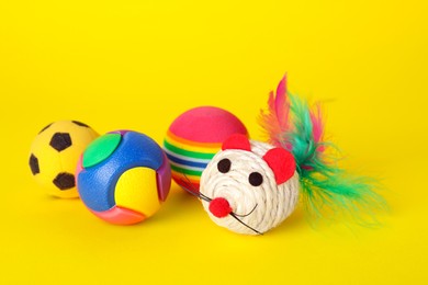 Photo of Various bright pet toys on yellow background