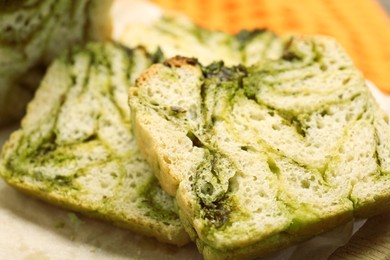 Slices of freshly baked pesto bread on wooden board, closeup