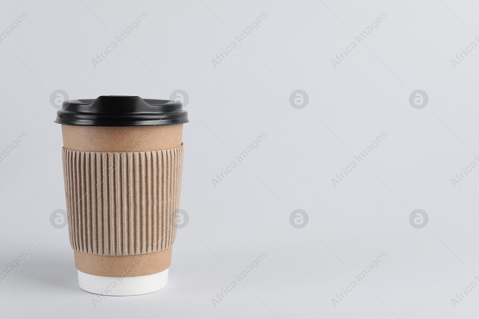 Photo of Paper cup with plastic lid on light background, space for text. Coffee to go