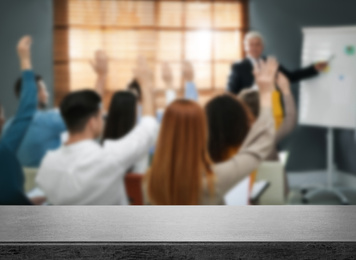 Empty stone surface and blurred view of seminar in modern office, closeup. Space for text 