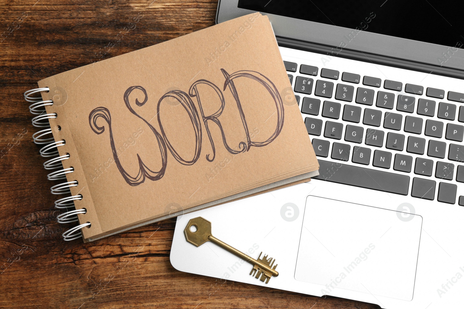 Photo of Metal key, laptop and notebook on wooden table, flat lay. Keyword concept