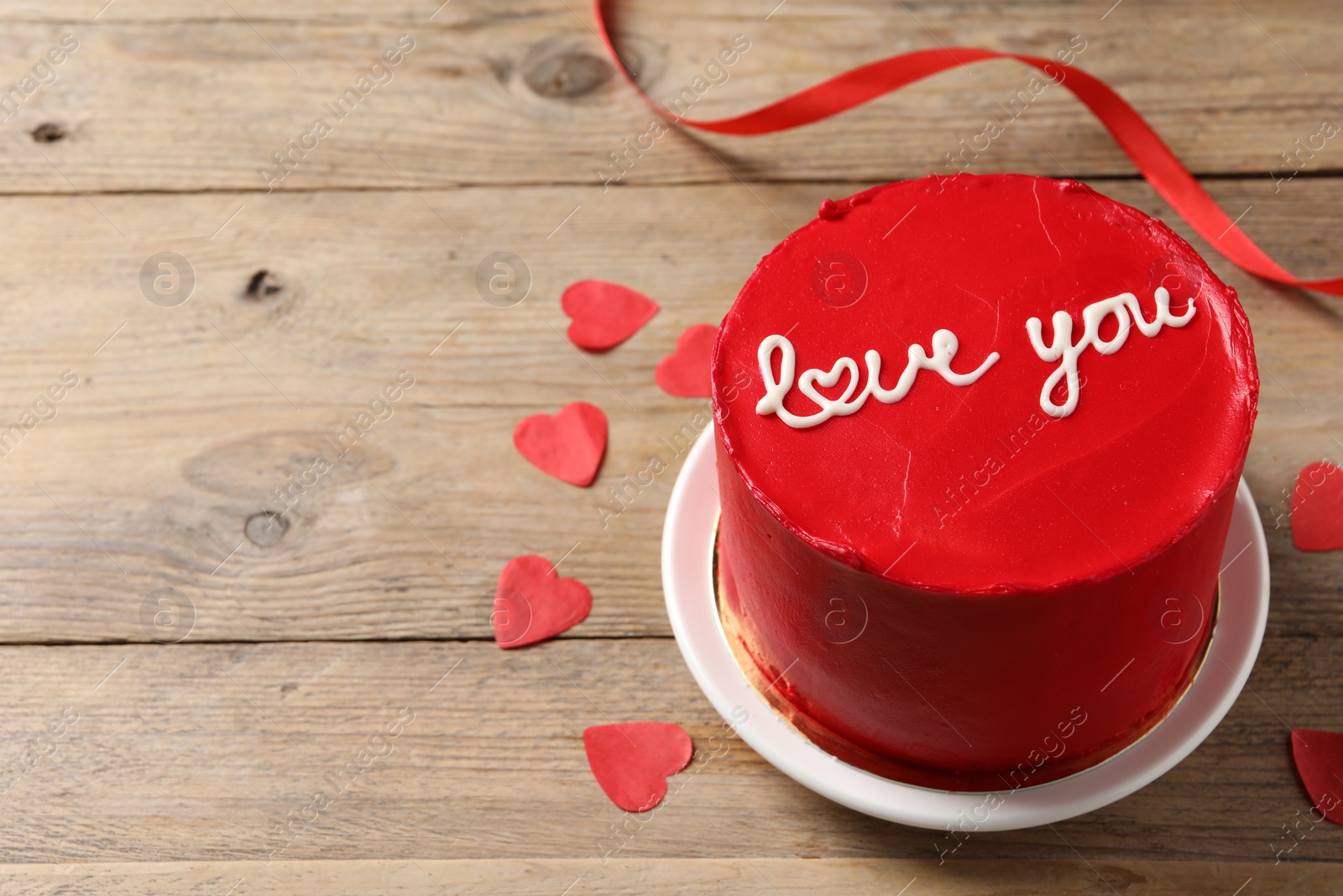 Photo of Bento cake with text Love You and paper hearts on wooden table, space for text. St. Valentine's day surprise