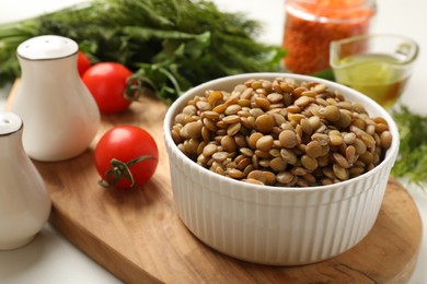 Photo of Delicious lentils in bowl served on table, closeup