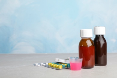 Photo of Syrups and different cough remedies on table. Space for text