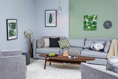 Photo of Stylish living room interior with comfortable sofa and table