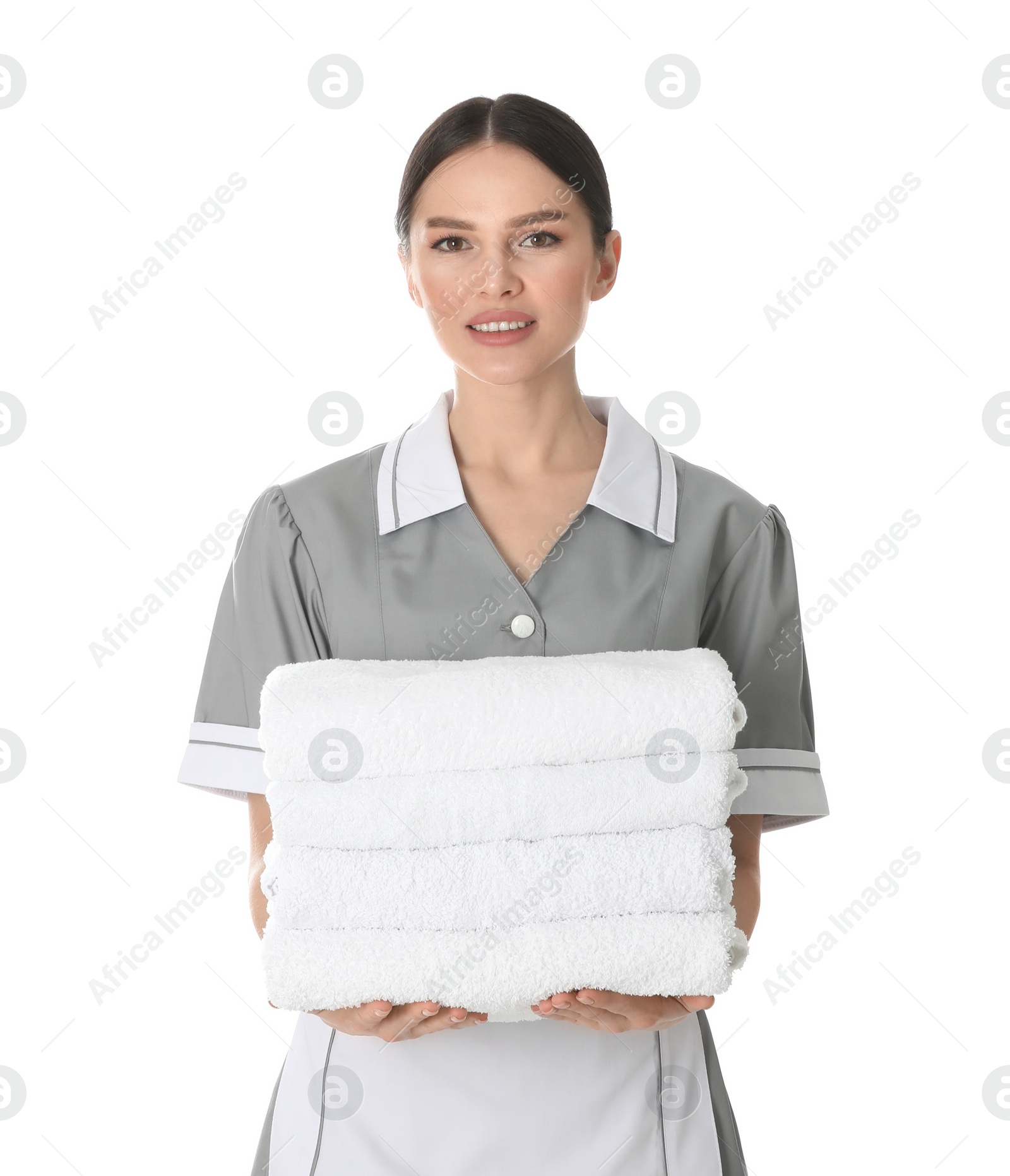 Photo of Young chambermaid holding stack of fresh towels on white background