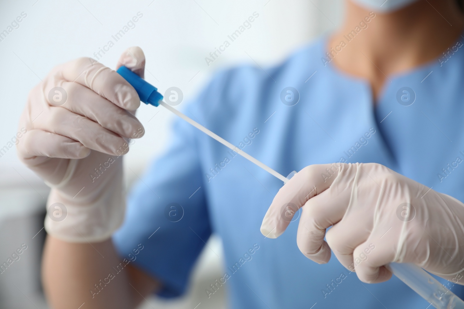 Photo of Doctor holding buccal cotton swab and tube for DNA test in clinic, closeup