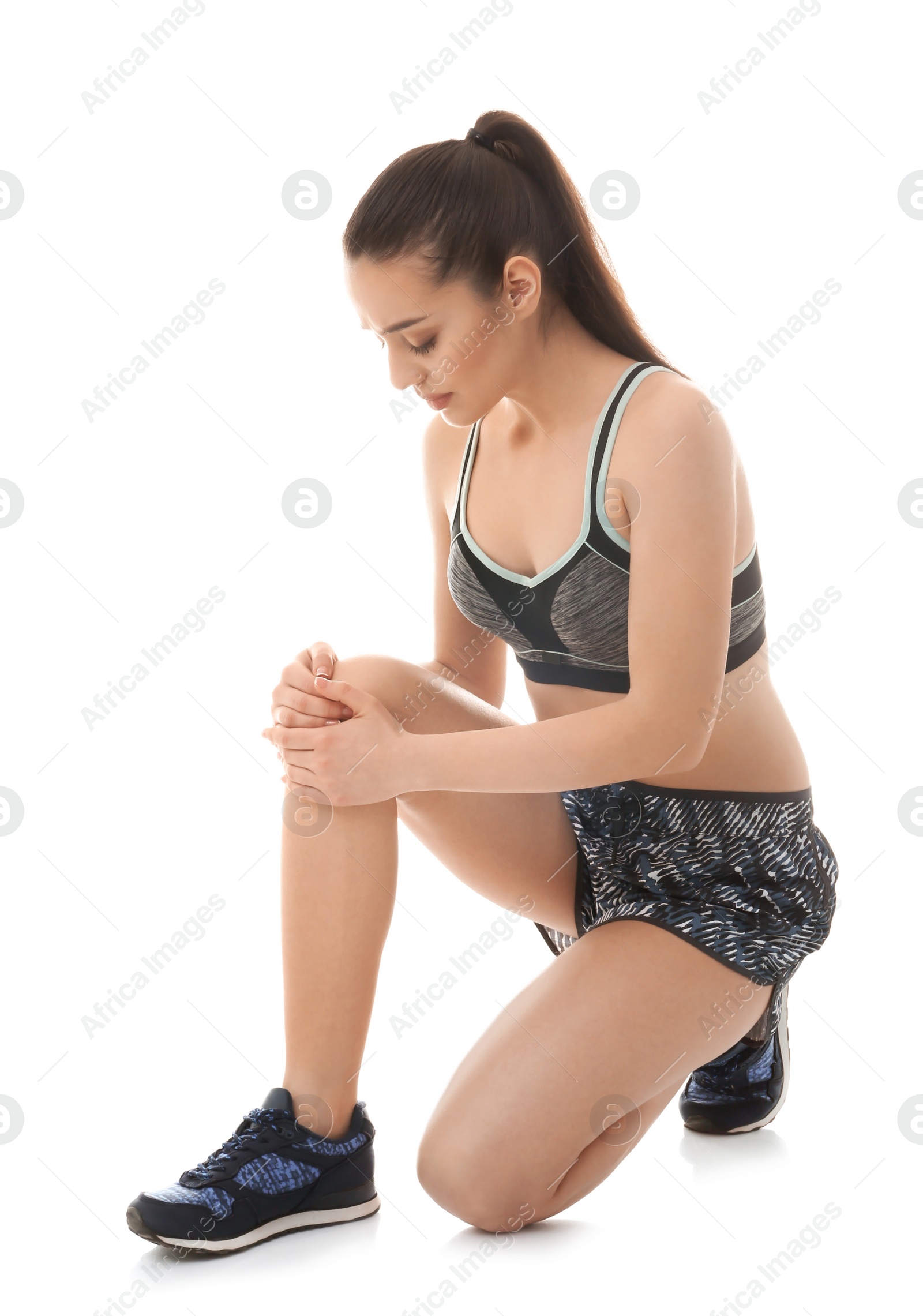 Photo of Young woman suffering from pain in knee on white background