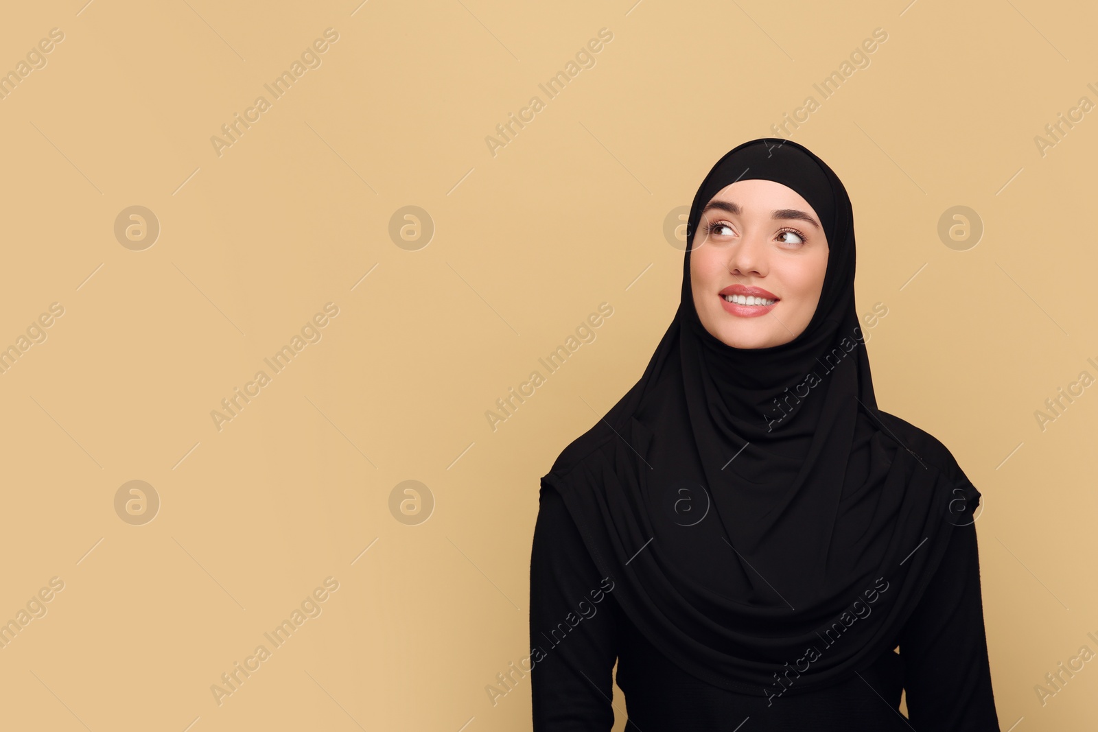 Photo of Portrait of Muslim woman in hijab on beige background, space for text