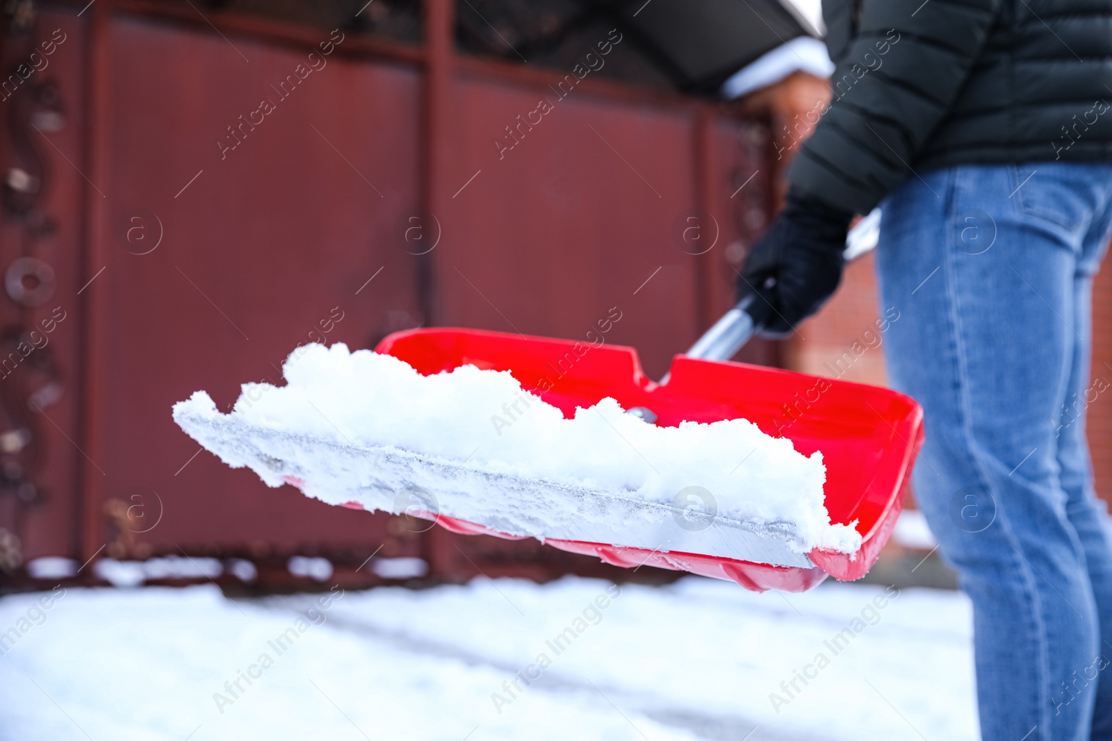 Photo of Person shoveling snow outdoors on winter day, closeup