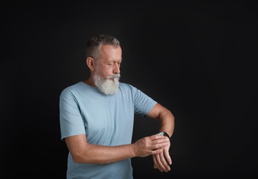 Portrait of handsome senior man on black background