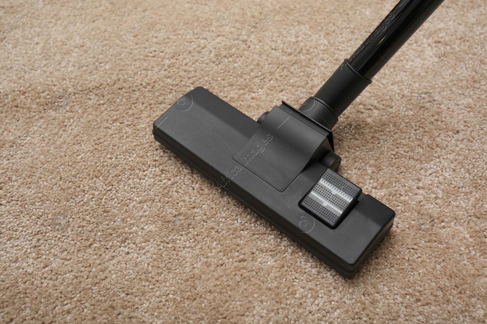 Photo of Removing dirt from carpet with modern vacuum cleaner indoors