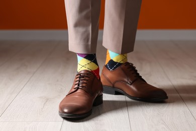 Man wearing stylish shoes and colorful socks indoors, closeup