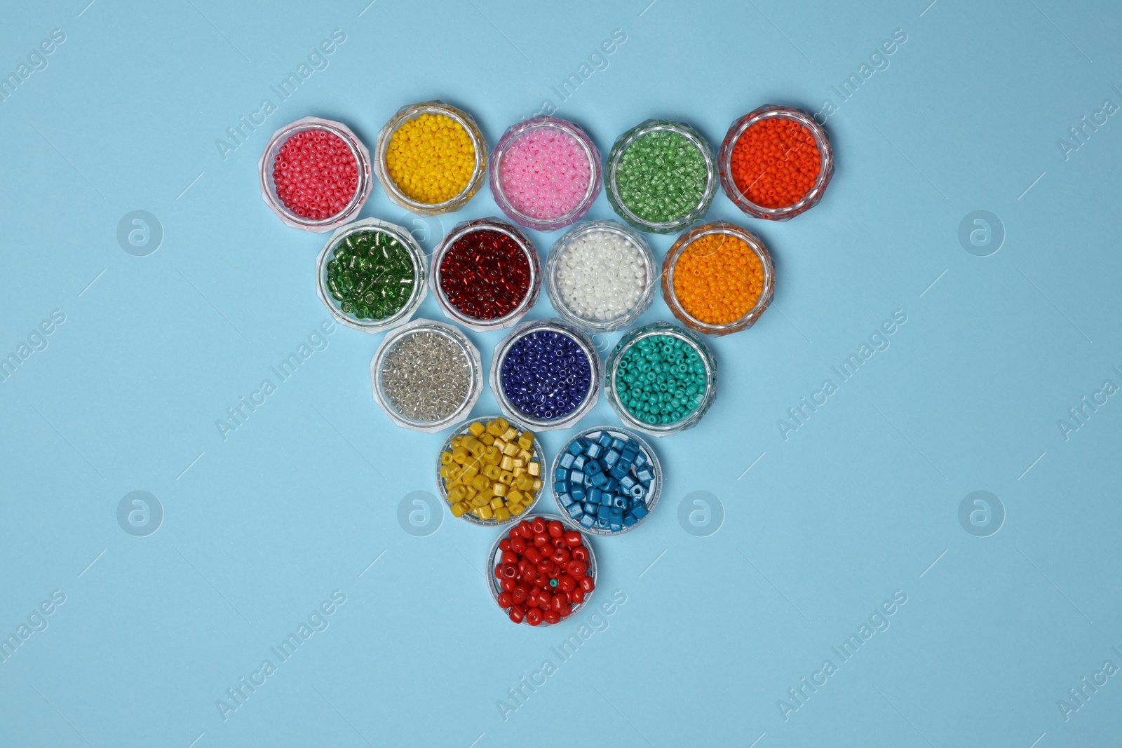 Photo of Flat lay composition with different colorful beads on light blue background