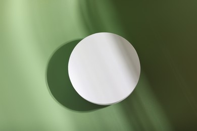 Photo of Round podium for product presentation on pale light green background, top view