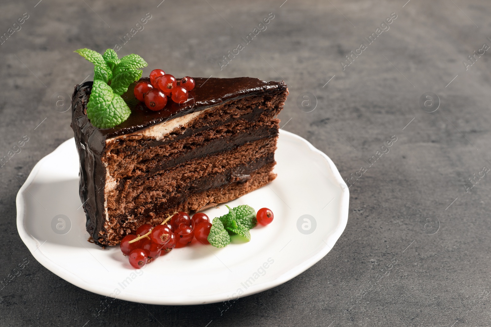 Photo of Plate with tasty homemade chocolate cake on grey table