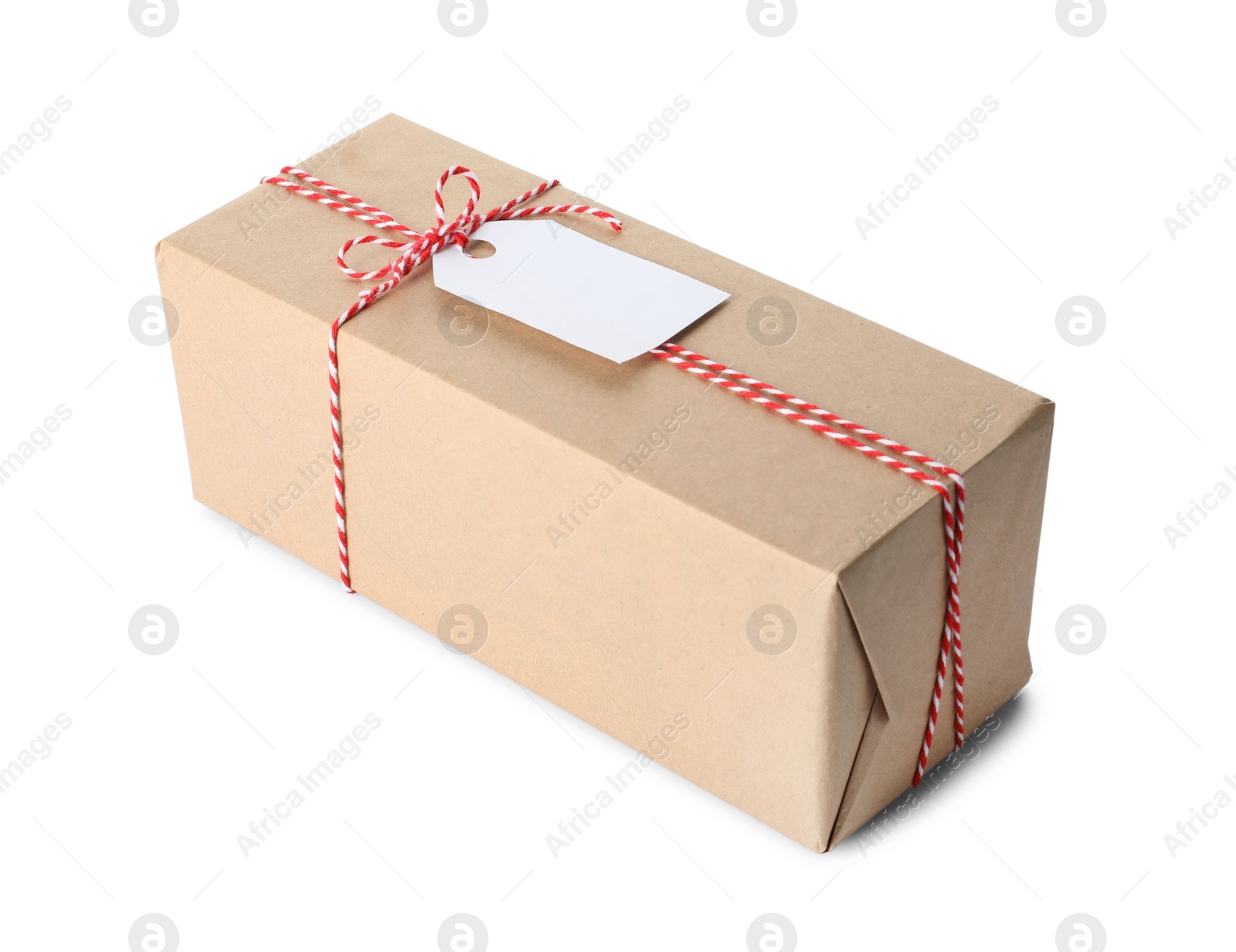 Photo of Gift box wrapped in kraft paper with bow and tag isolated on white