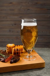 Photo of Glass of beer, delicious fried steak and corn on grey table