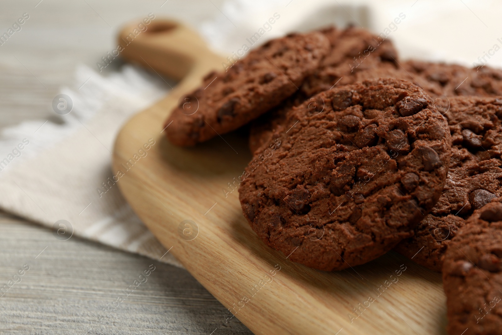 Photo of Delicious chocolate chip cookies on light wooden table, closeup