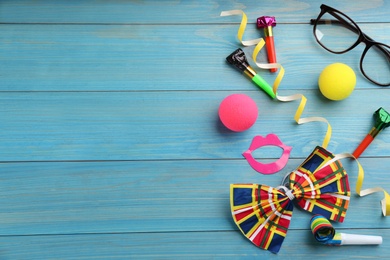 Photo of Flat lay composition with clown's items on light blue wooden table, space for text