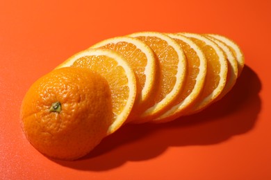 Photo of Slices of juicy orange on terracotta background