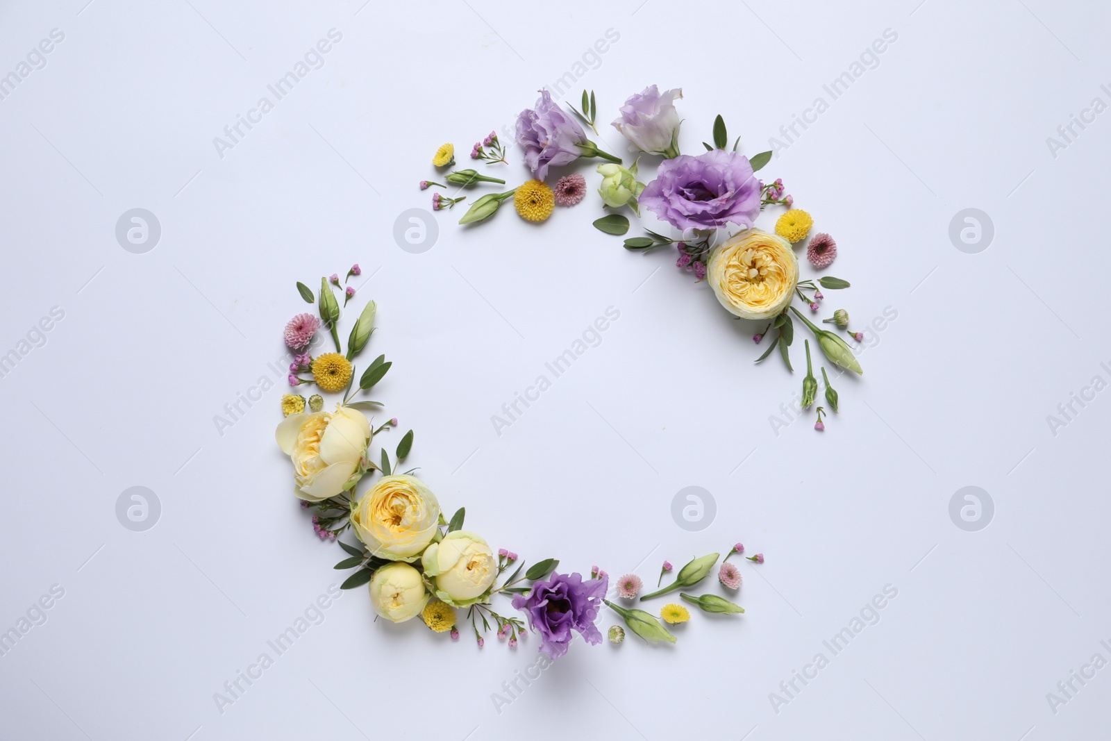 Photo of Wreath made of beautiful flowers and green leaves on light background, flat lay. Space for text