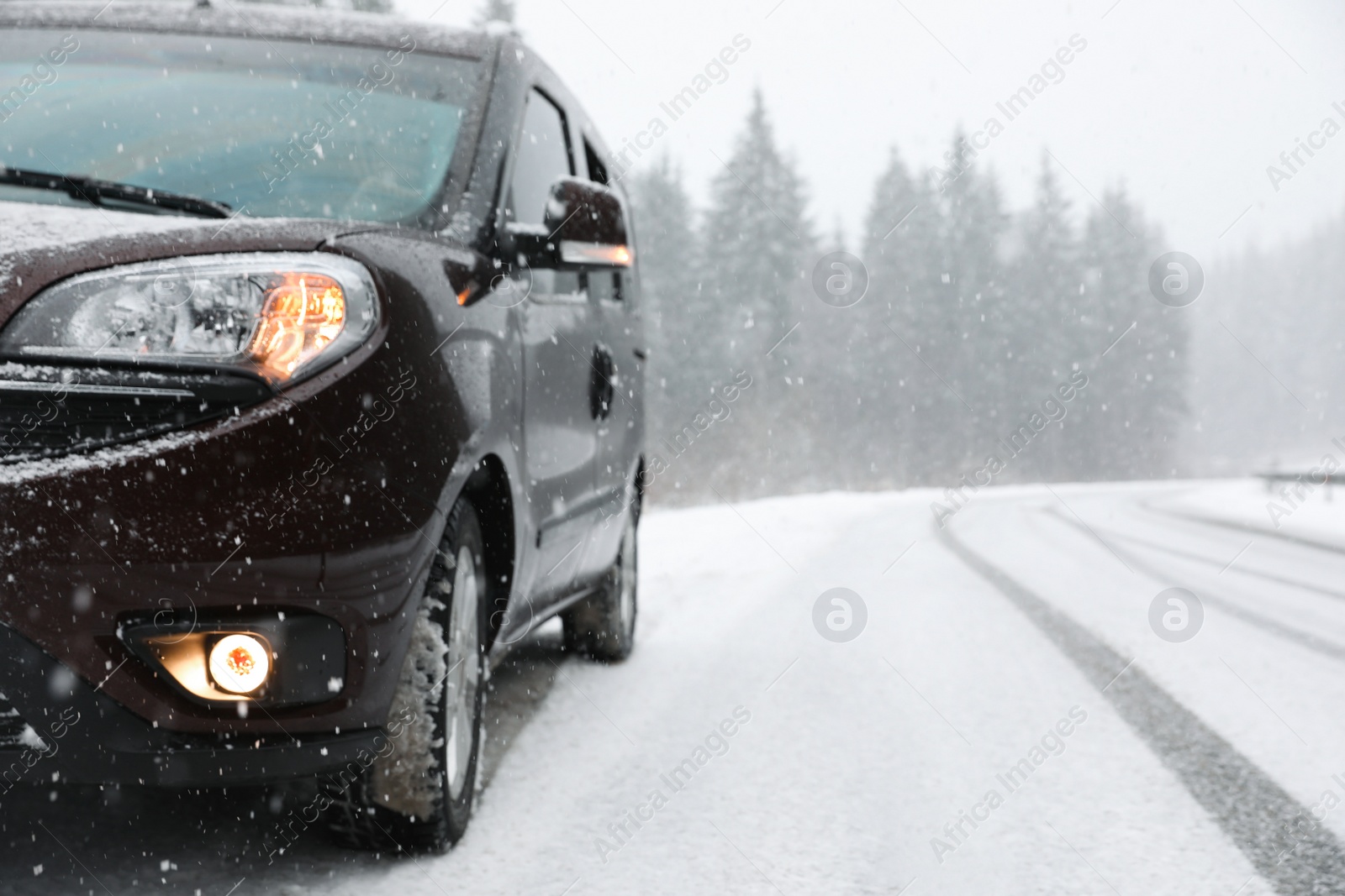 Photo of Country road with car on snowy winter day. Space for text