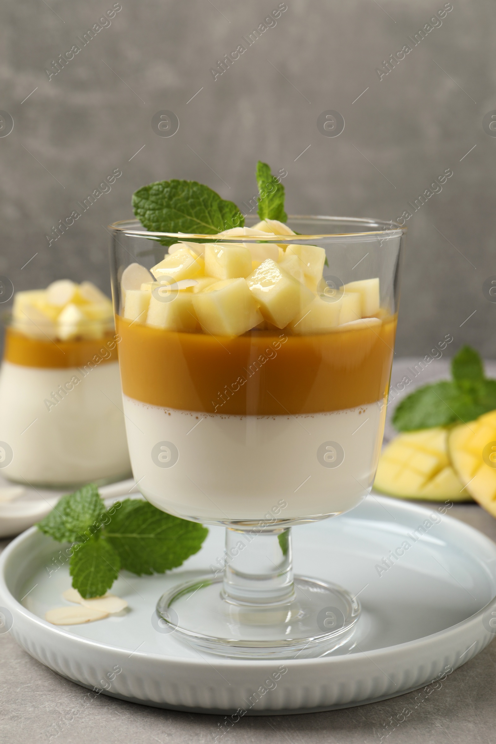 Photo of Delicious panna cotta with mango on grey table