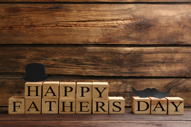 Photo of Phrase HAPPY FATHER'S DAY made with cubes on wooden background. Space for text