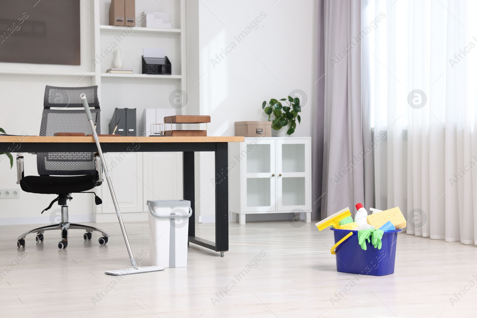 Photo of Cleaning service. Mop and buckets with supplies in office