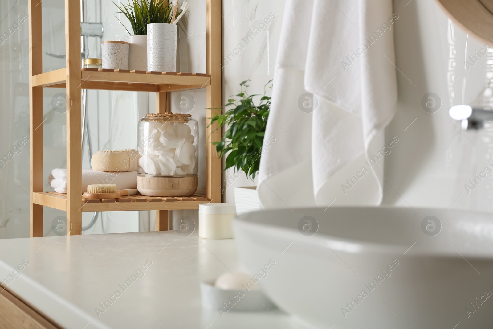 Photo of Shelving unit with toiletries in bathroom interior