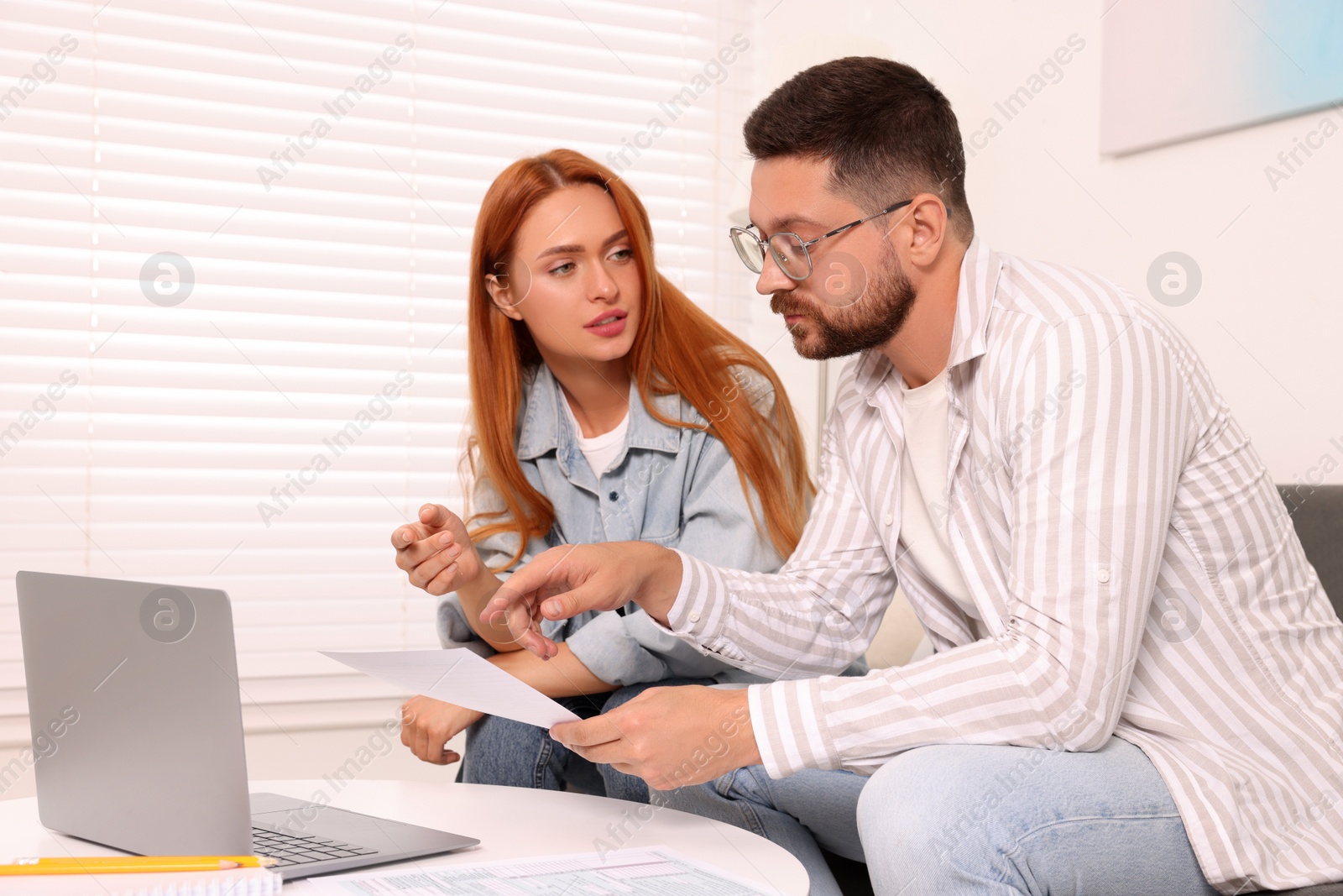 Photo of Couple doing taxes at table in living room