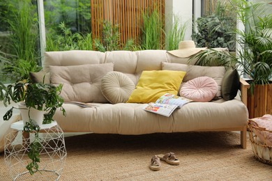 Indoor terrace interior with comfortable sofa and green plants