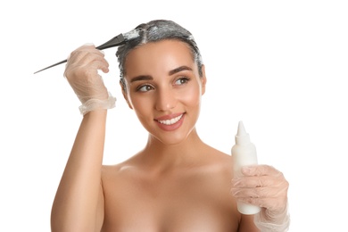 Photo of Young woman dyeing her hair against white background