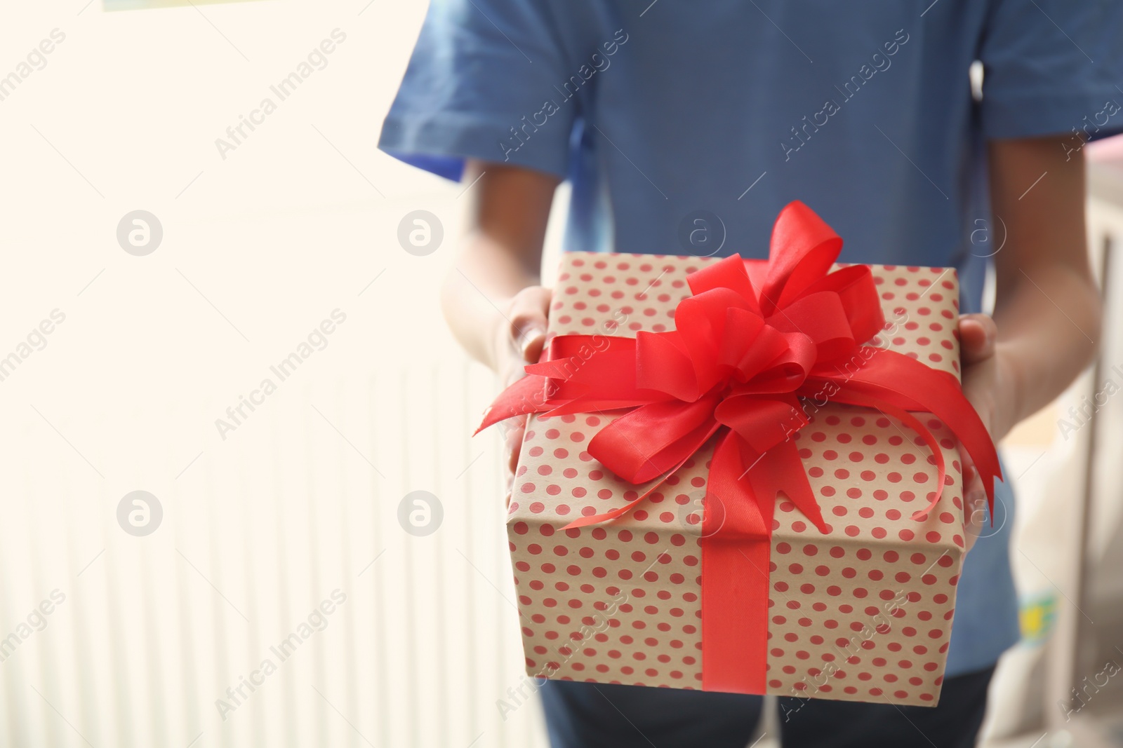 Photo of Little child with gift box for Mother's Day on light background