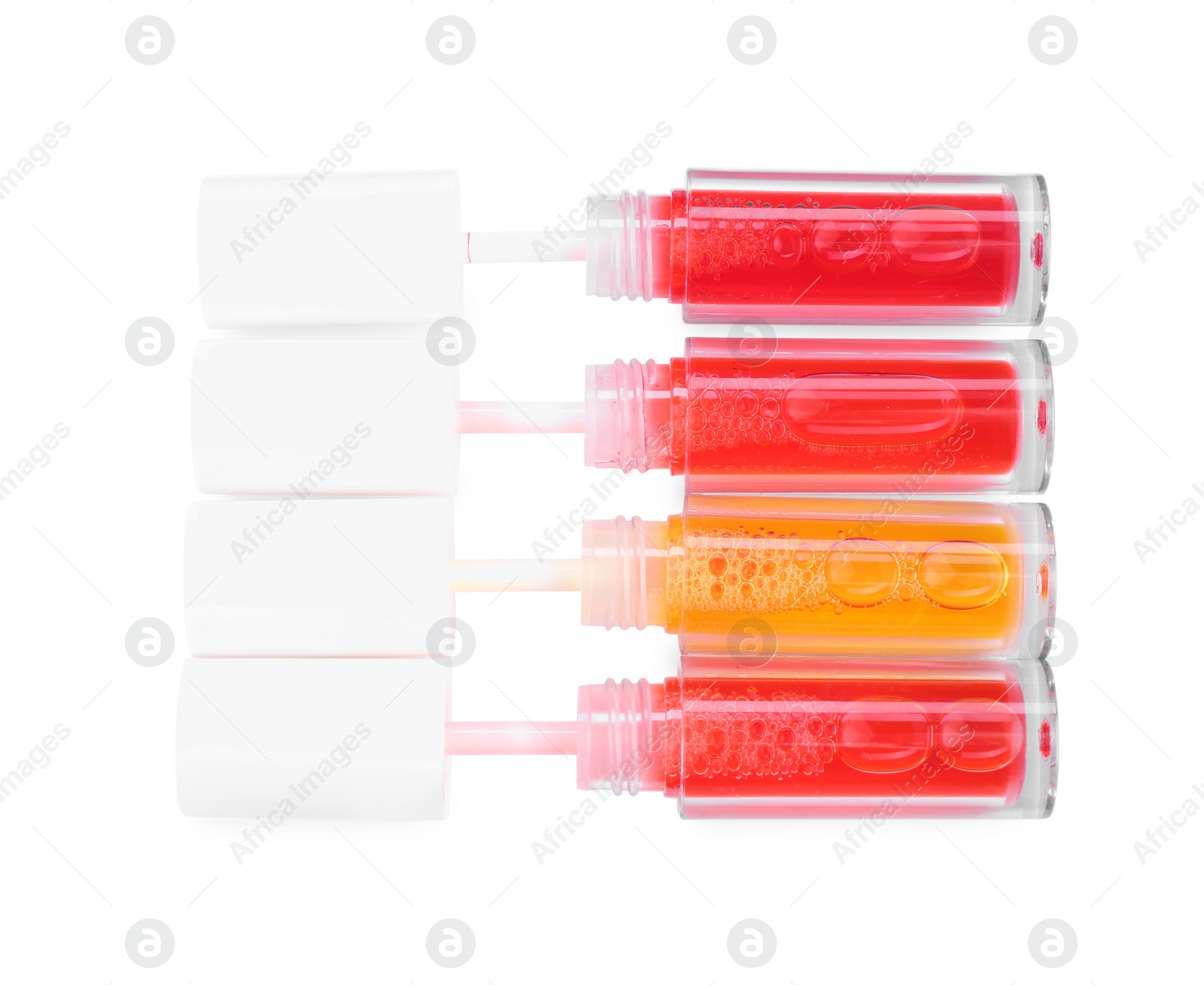 Photo of Bright lip glosses isolated on white, top view