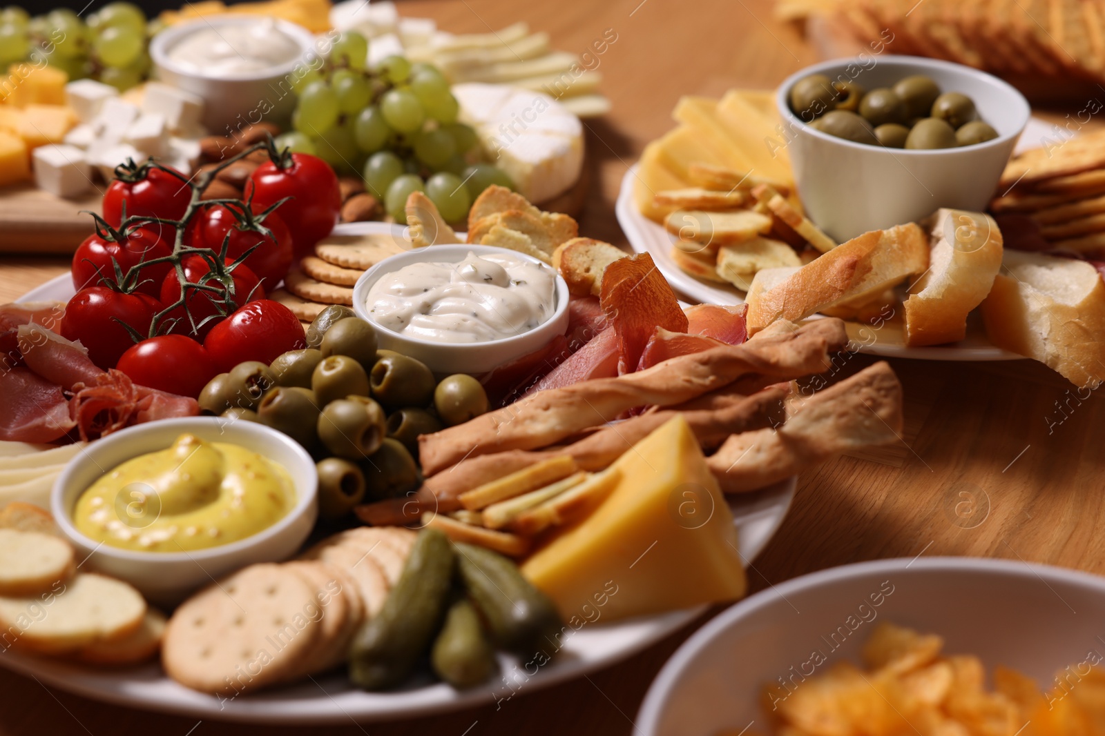 Photo of Assorted appetizers served on wooden table, closeup