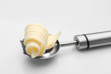 Photo of Knife with butter curl on white background