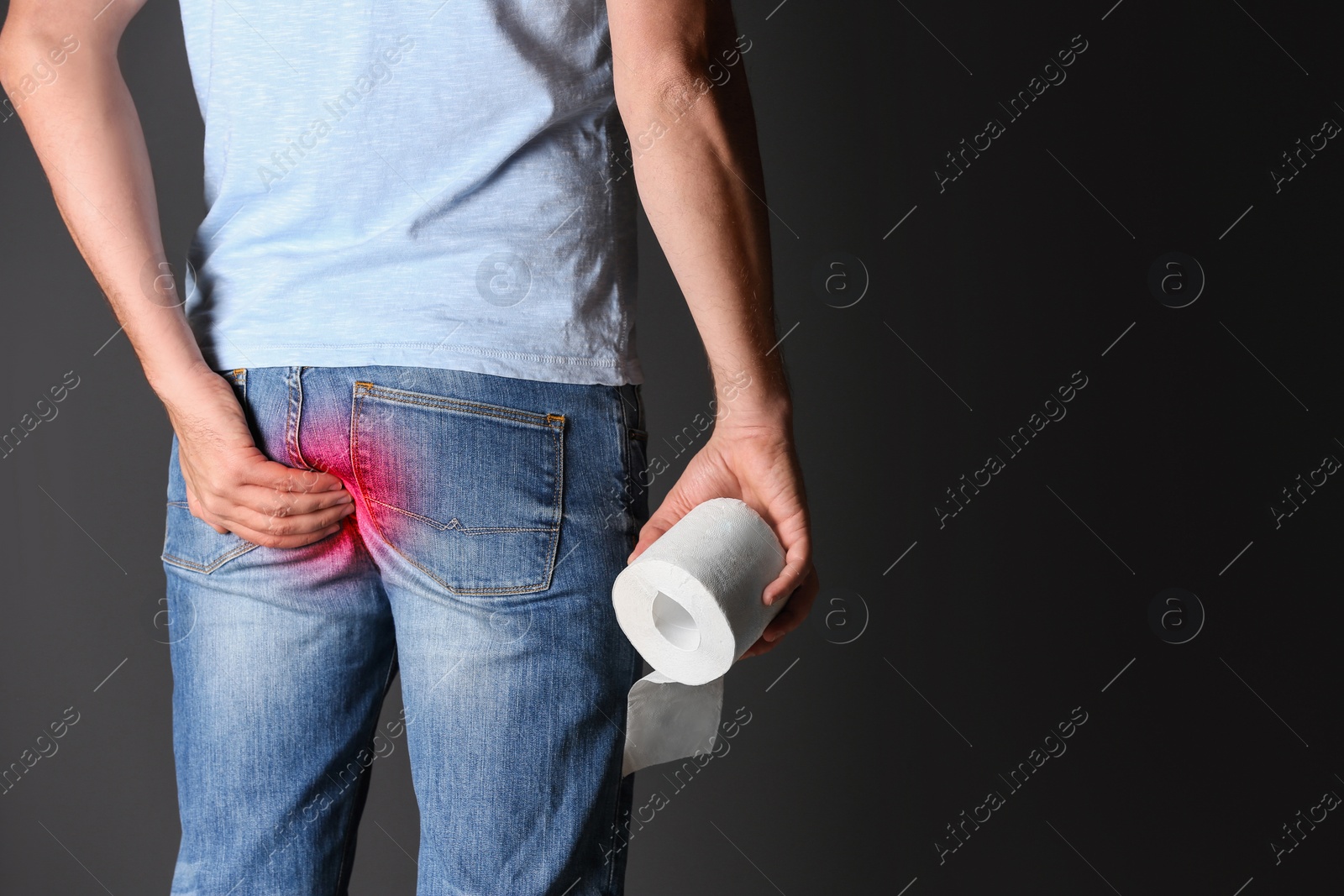 Image of Man with toilet paper suffering from hemorrhoid on black background, closeup. Space for text