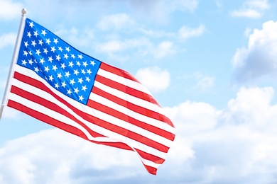 Photo of American flag outdoors on cloudy day. Space for text