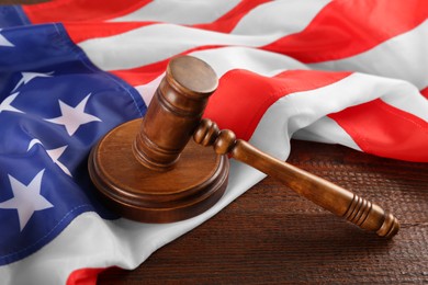Photo of Judge's gavel and American flag on wooden table