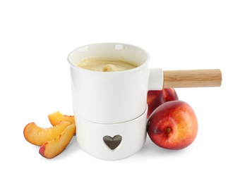 Pot with chocolate fondue and peaches on white background