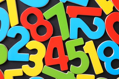 Photo of Colorful numbers on black background, top view