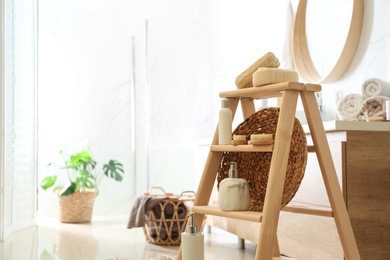 Photo of Dispensers and different toiletries on decorative ladder in bathroom. Idea for interior design