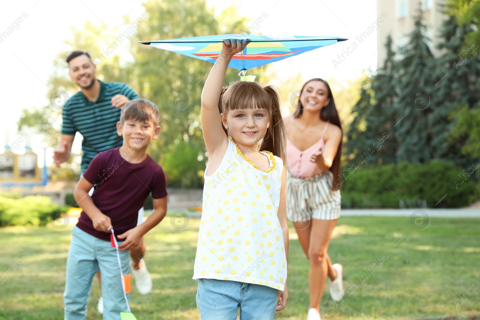 Photo of Happy family with children spending time together in green park on sunny day