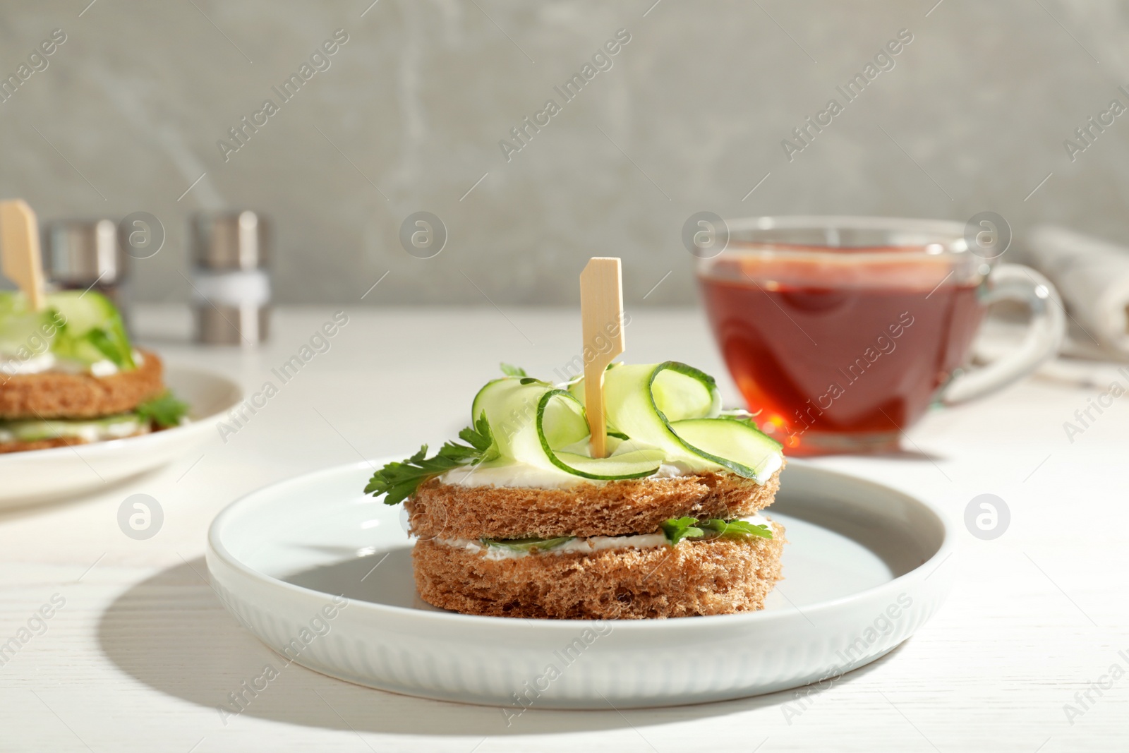 Photo of Plate with traditional English cucumber sandwich on table