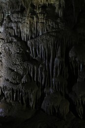 Photo of Picturesque view of many stalactite formations in dark cave